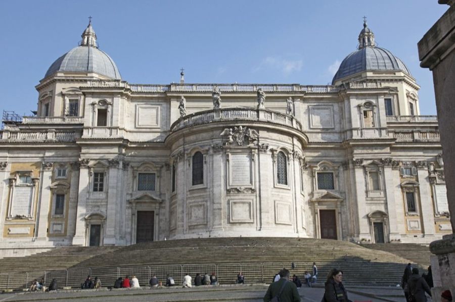 The apse end of the Basilica of Santa Maria Maggiore in Rome, twin domes and a curved travertine facade above a wide flight of steps.