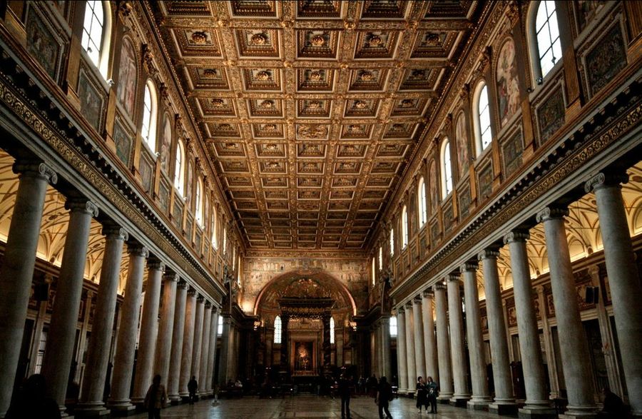 The nave of Santa Maria Maggiore looking toward the altar, two colonnades of matched columns under a gilded coffered ceiling.
